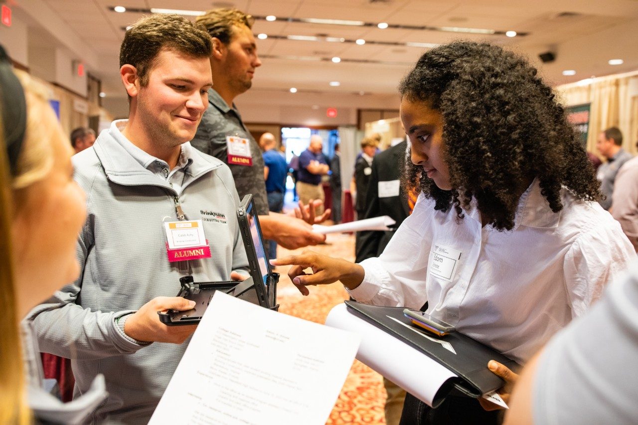 An alumnus talks with a Virginia Tech student during a career fair.