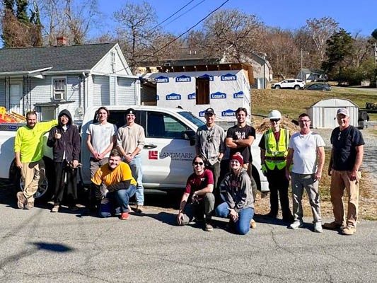 (From left) Mark Edwards, Jiho Lyu, Chris Donaldson, Cooper Martin, Alex Alday, Ryan Baum, Isaac Zheng, Rebecca Greiner, Zach Meiners, Jacob Kmieciak, and Chris Parks work on the home, saving the family money as they expand. Photo courtesy of Sarah Bates. 