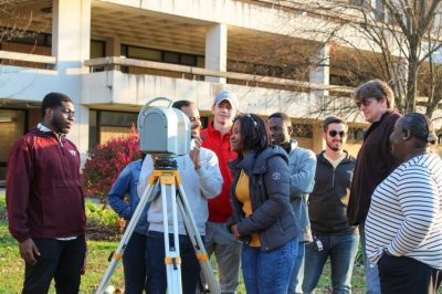 Students and their professor set up an array of sensors to digitally map a practice worksite on the Virginia Tech campus.
