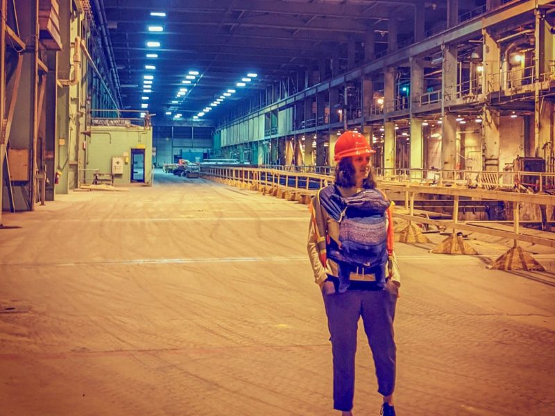 Parent stands in an orange hardhat with a baby.