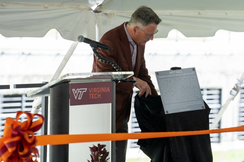 Virginia Tech President Tim Sands unveils a plaque that will hang in Hitt Hall honoring its namesake family. Photo by Lee Friesland for Virginia Tech.