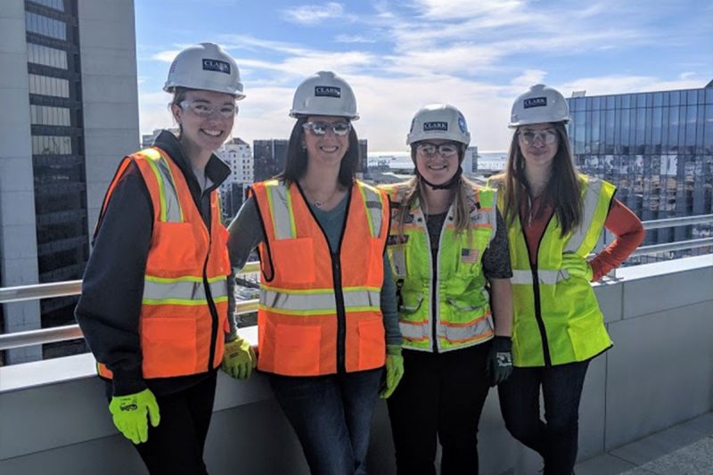 group of students in construction attire on top of building