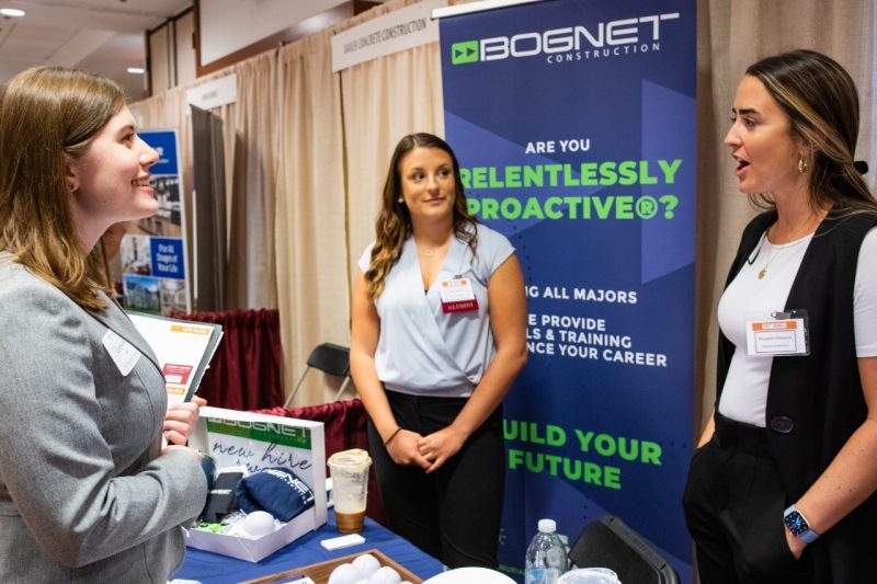 A student talks with recruiters during a career fair.