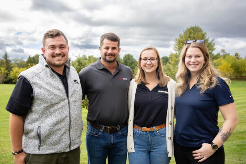 The Young Alumni Committee pictured (from left to right) Jacob Lescault, Sam Savoia, Allie Vogrig, and Danielle Hill smile outside.