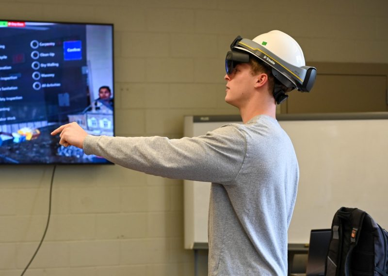 A student uses a virtual reality headset to explore a build project.