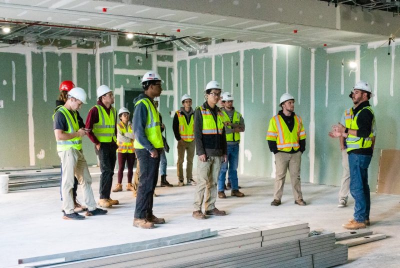 Students observe a lesson from inside a work site.