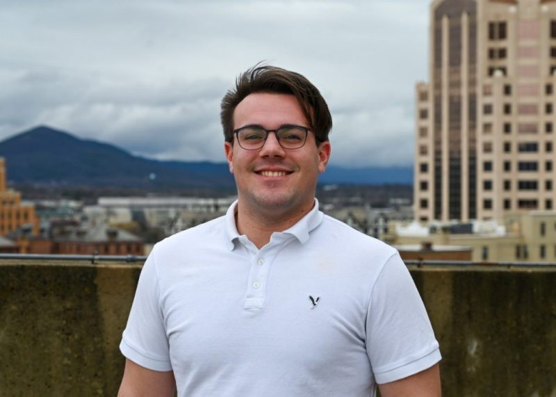 Man smiles with Roanoke City as the background.