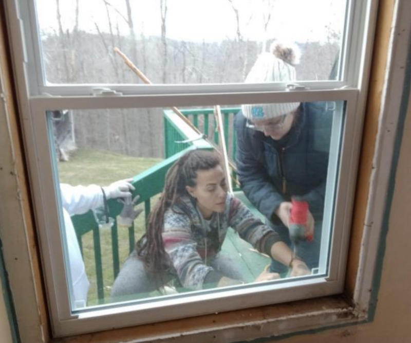 Students work on a build project outside of a home.